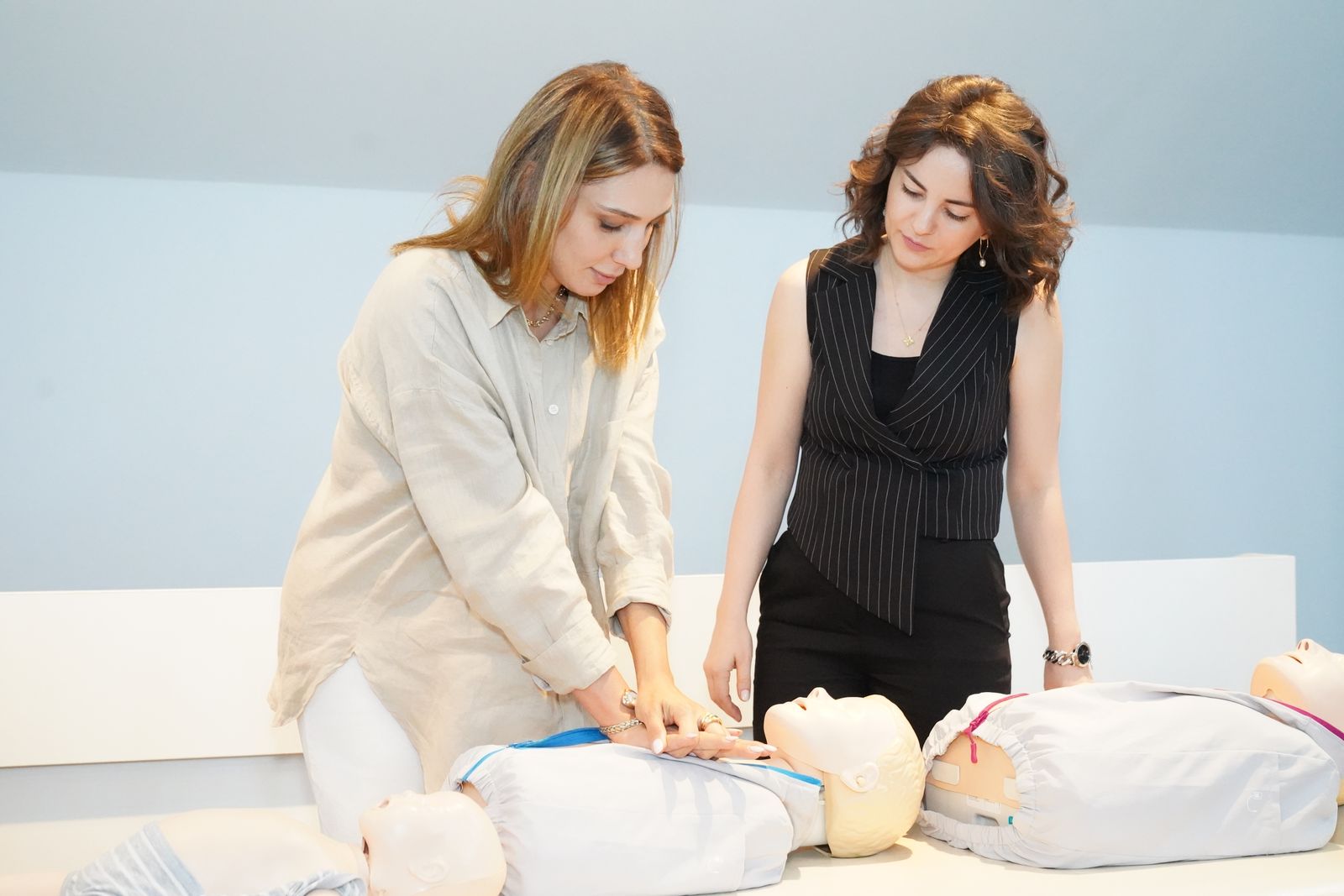 Participants practicing CPR skills together on training manikins