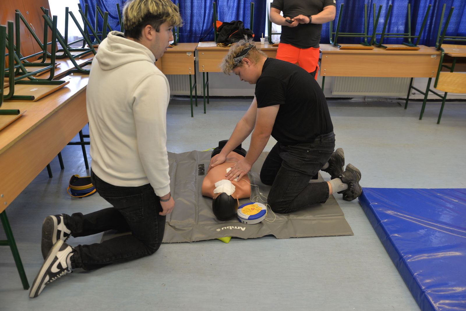 CPR instructor guiding learners as they practice on training mannequins